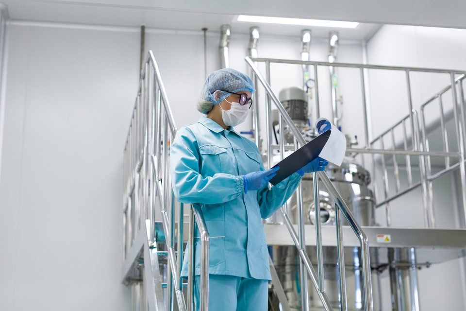 Analyst reviewing instrument readings in a GLP-compliant pharmaceutical laboratory